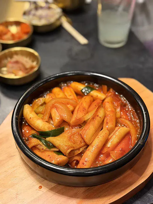 Spicy tteokbokki rice cakes with fish cakes and onions in red sauce at Mr.Kimchi Korean Bistro, a Korean Restaurant in Oklahoma City
